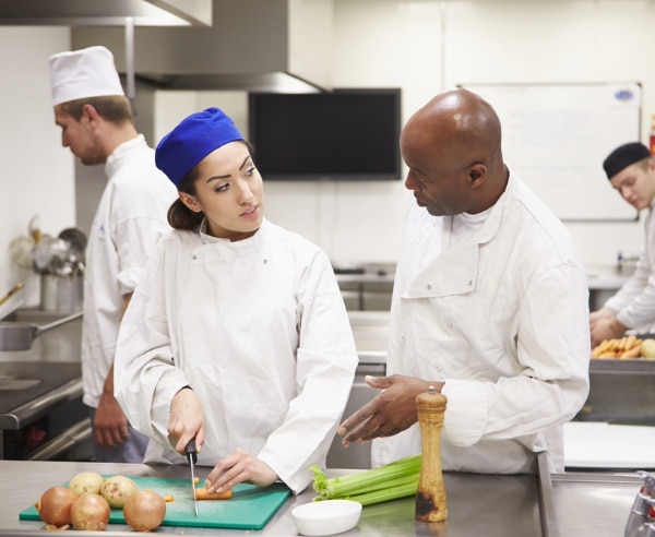 Man and a woman cooking in a commercial kitchen