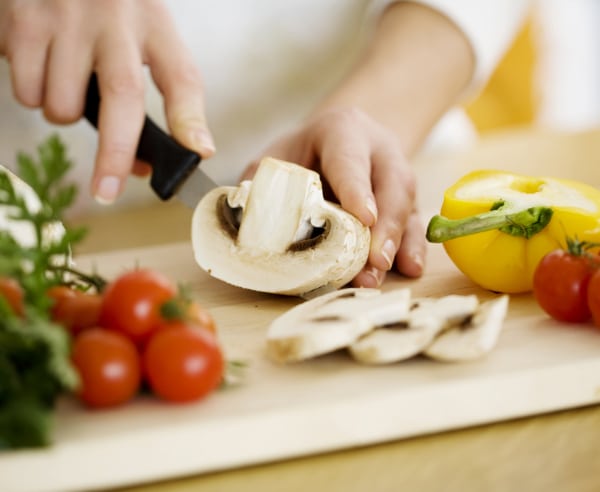 Decorative image of person chopping up vegetables